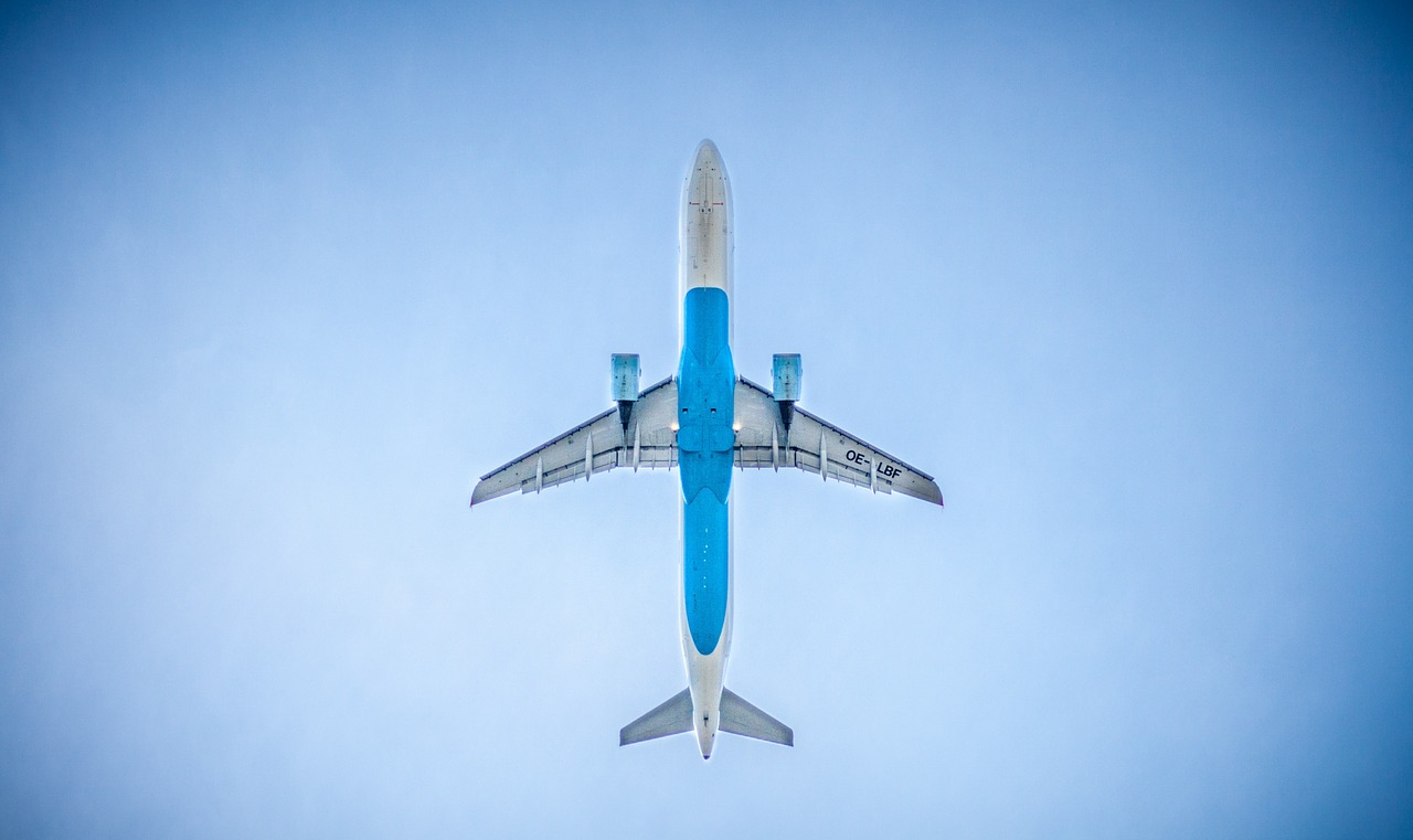 מבט מתחת למטוס כחול-לבן בשמיים - תקן AS 9100 - IQC